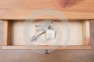 Bunch of door keys with keychain in open drawer