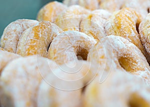 Bunch of Doughnuts Cruller with White Powder Sugar Topping. Sweet Potato Donut.