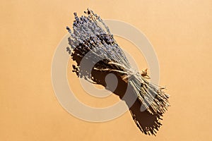 Bunch of dry lavender pounded with nattural rope on beige background. Aromatherapy and alternative medicine