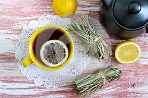 A bunch of dry lemongrass, fresh lemon, teapot and cup of tea. Tea Ingredients. The culture of tea drinking.