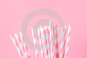 Bunch of Elegant White Striped Paper Drinking Straws on Pink Background. Birthday Party Babyshower Invitation Card Fun Kids
