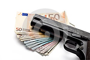 Bunch of euro banknotes with a gun