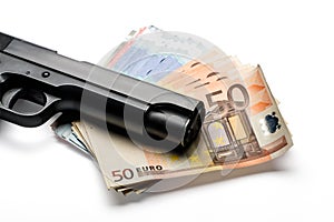 Bunch of euro banknotes with a gun