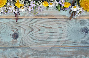 Bunch of fieldflowers,daisies, buttercups, Pentecostal flowers, dandelions on a oldwooden background with empty copy space