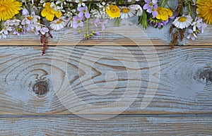 Bunch of fieldflowers,daisies, buttercups, Pentecostal flowers, dandelions on a oldwooden background with empty copy space