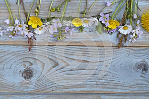 Bunch of fieldflowers,daisies, buttercups, Pentecostal flowers, dandelions on a oldwooden background with empty copy space