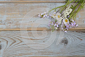 Bunch of fieldflowers,daisies, buttercups, Pentecostal flowers, dandelions on a oldwooden background with empty copy space photo