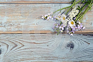 Bunch of fieldflowers,daisies, buttercups, Pentecostal flowers, dandelions on a oldwooden background with empty copy space photo