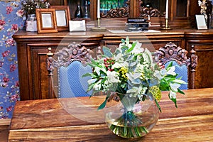 Bunch of flowers in jug on table in old-fashioned photo