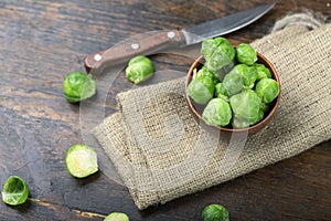 Bunch of fresh Bruxelles sprouts in a cup on wooden background