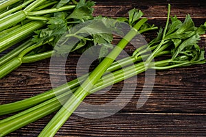 Bunch of fresh celery stalk with leaves on wooden background