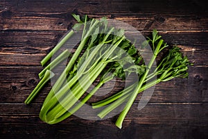 Bunch of fresh celery stalk with leaves on wooden background