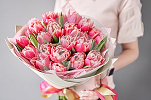Bunch of fresh cut spring flowers. Crimson color tulips in woman hand. Spring bouquet of red tulips in hands.