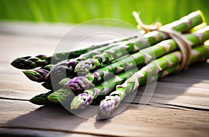 Bunch of fresh green asparagus spears on rustic wooden table.