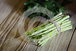 Bunch of fresh green asparagus on a wooden table.