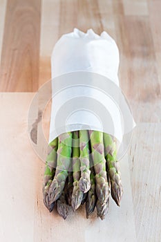 Bunch of fresh green asparagus on a wooden table, vertical