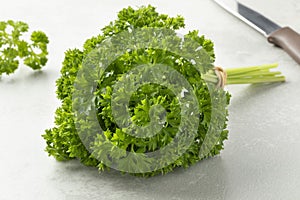 Bunch of fresh green curly leaf parsley on a cutting board