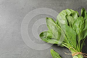 Bunch of fresh green healthy spinach on grey table. Space for text