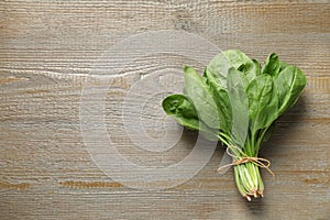 Bunch of fresh green healthy spinach on wooden table. Space for text