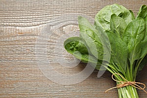 Bunch of fresh green healthy spinach on wooden table. Space for text