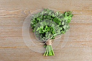 Bunch of fresh green parsley leaves on light wooden table, top view