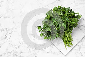 Bunch of fresh green parsley on marble table, top view. Space for text