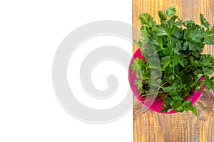 A bunch of fresh green parsley in a pink jar on table ready to eat. isolate