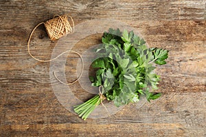 Bunch of fresh green parsley and twine on wooden background