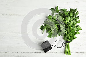 Bunch of fresh green parsley and twine on wooden background, flat lay