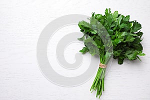 Bunch of fresh green parsley on white table, top view. Space for text