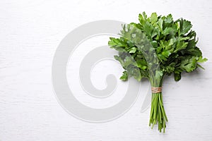 Bunch of fresh green parsley on white table, top view. Space for text