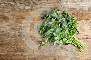 Bunch of fresh green parsley on wooden background. Space for text