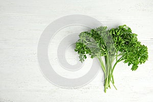 Bunch of fresh green parsley on wooden background. Space for text