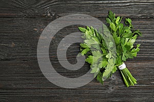 Bunch of fresh green parsley on wooden background, view from above