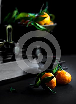 A bunch of fresh juicy clementines with green leaves in a scale