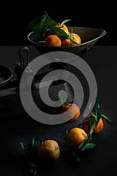 A bunch of fresh juicy clementines with green leaves in a scale