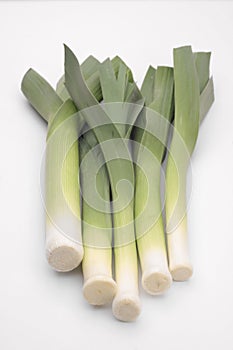 Bunch of fresh leeks over white