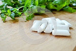Bunch of fresh mint and gum pads on wooden background
