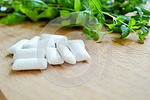 Bunch of fresh mint and gum pads on wooden background