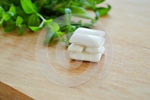 Bunch of fresh mint and gum pads on wooden background