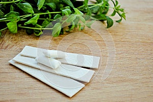 Bunch of fresh mint, lozenges and gum pads on wooden background