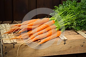 Bunch on fresh orange carrots on wooden box