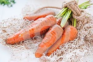 Bunch of Fresh organic dirty carrots from farm market on the white wooden background. Vegetables. Healthy food concept. Vegetarian