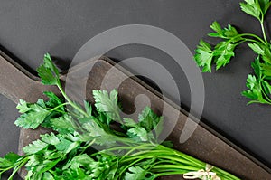 Bunch of fresh parsley with chopping board on rustic table, green leaf vegetable