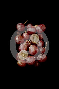 Bunch of fresh red grapes over black background