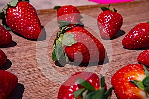 Bunch of fresh red strawberries drying on a wooden surface