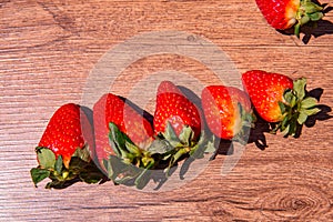 Bunch of fresh red strawberries drying on a wooden surface