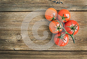 Bunch of fresh ripe red tomatoes over a rustic wood background