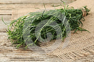 Bunch of fresh tarragon on wooden table, closeup
