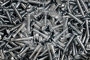 Bunch of galvanized stainless bolts with round head, hardware background, silver screws